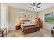 This spacious main bedroom has a ceiling fan and a large window, creating a relaxing retreat at 108 Wagon Place, Rotonda West, FL 33947