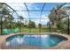 Inviting private pool with screened enclosure, surrounded by lush landscaping at 108 Wagon Place, Rotonda West, FL 33947