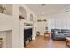Cozy living room with a fireplace, custom shelving, hardwood floors, and window shutters at 117 Cable Dr, Rotonda West, FL 33947