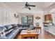 Spacious living room with a plush leather couch, ceiling fan and a kitchen nook at 117 Cable Dr, Rotonda West, FL 33947