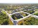 An aerial shot showcases this single-Gathering home with a manicured lawn and circular driveway at 13575 Chenille Dr, Port Charlotte, FL 33981