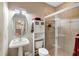 Stylish bathroom featuring a tiled shower, pedestal sink, and well-placed storage at 13575 Chenille Dr, Port Charlotte, FL 33981