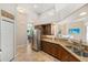 Bright kitchen with stainless steel refrigerator and granite countertops overlooking the living space at 13575 Chenille Dr, Port Charlotte, FL 33981