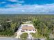 Stunning aerial view of a beautiful home with a circular driveway and lush green surroundings at 1600 Thomas St, Englewood, FL 34223
