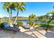 Relaxing backyard with lounge chairs and beautiful views of the lake and landscaping at 214 W Pine Valley Ln, Rotonda West, FL 33947