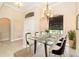Bright dining room with glass table, elegant chandelier, and natural light from the window at 214 W Pine Valley Ln, Rotonda West, FL 33947