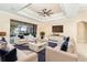 Spacious living room with tray ceilings, lots of seating, and a view of the outdoor pool area at 214 W Pine Valley Ln, Rotonda West, FL 33947