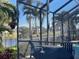 Screened-in patio with Weber grill overlooking lake and lush landscaping at 214 W Pine Valley Ln, Rotonda West, FL 33947