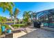 Beautiful outdoor patio with a grill and a view of the pool, lake, and lush landscaping at 214 W Pine Valley Ln, Rotonda West, FL 33947