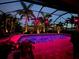A beautiful backyard pool area is illuminated with neon lights at night at 214 W Pine Valley Ln, Rotonda West, FL 33947