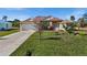 Charming single-story home with lush green lawn and flowering shrubbery adding color to the manicured landscape at 411 Boundary Blvd, Rotonda West, FL 33947