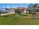 Attractive single-story home featuring well-maintained landscaping, a colorful flowering shrub and an attached two-car garage at 411 Boundary Blvd, Rotonda West, FL 33947