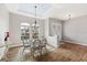 Elegant dining area with a modern chandelier, a glass-top table, and plenty of natural light at 497 Rotonda Cir, Rotonda West, FL 33947
