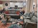 Comfortable living room features stylish leather sofas and a vibrant floral rug at 5560 Club View Ln, North Port, FL 34287