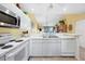 Bright kitchen with stainless steel appliances and tile flooring overlooking the dining and living area at 6800 Placida Rd # 235, Englewood, FL 34224