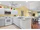 Bright kitchen with white appliances, white cabinetry, laminate countertops, and views of the living room at 6800 Placida Rd # 235, Englewood, FL 34224