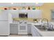 Cozy kitchen featuring white appliances, white cabinetry, laminate countertops, and tile floor at 6800 Placida Rd # 235, Englewood, FL 34224