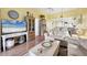 Bright and open living room features wood floors, neutral furniture, and an open floor plan at 6800 Placida Rd # 235, Englewood, FL 34224