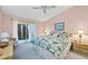 Bright main bedroom with a ceiling fan and sliding glass door leading to an outdoor area at 6800 Placida Rd # 235, Englewood, FL 34224