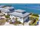 Coastal home with a metal roof and lush landscaping overlooking the water at 7180 Brittany Cir, Englewood, FL 34224
