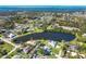 An aerial shot of a home with a pool, set against a beautiful lake and lush neighborhood at 891 Harmony Ln, Englewood, FL 34223