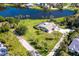 Aerial shot of a home with a pool, situated on a tranquil lake amidst lush greenery at 891 Harmony Ln, Englewood, FL 34223