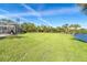 A lush green lawn stretches out towards a tranquil body of water at 891 Harmony Ln, Englewood, FL 34223