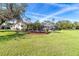 Expansive backyard featuring a patio, in-ground pool, lush lawn, and serene water views at 891 Harmony Ln, Englewood, FL 34223
