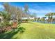 Lush backyard with a mature tree and wooden swing overlooking the waterfront at 891 Harmony Ln, Englewood, FL 34223