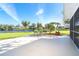 Inviting patio area with chairs and bench overlooking a tranquil lake at 891 Harmony Ln, Englewood, FL 34223