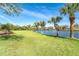 Expansive backyard with a waterfront view and mature palm trees at 891 Harmony Ln, Englewood, FL 34223