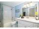 Well-lit bathroom with a bathtub, shower, marble countertop, and white vanity at 891 Harmony Ln, Englewood, FL 34223