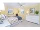 Bright bedroom featuring a yellow color scheme, ceiling fan, and a comfortable bed with patterned bedding at 891 Harmony Ln, Englewood, FL 34223