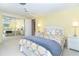 Comfortable bedroom with a mirrored closet and a queen bed featuring patterned bedding and soft colors at 891 Harmony Ln, Englewood, FL 34223