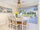 Elegant dining room featuring a table set for six, a ceiling fan, and sliding glass doors to the patio at 891 Harmony Ln, Englewood, FL 34223