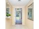 Bright foyer with tiled floor, mirrors, and view to the screened porch entrance, creating a welcoming first impression at 891 Harmony Ln, Englewood, FL 34223