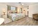 Bright main bedroom features a king-sized bed, windows, and a ceiling fan; it is well-lit with hardwood floors at 891 Harmony Ln, Englewood, FL 34223