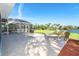 Spacious outdoor patio with chaise lounges and BBQ area offering serene lake views at 891 Harmony Ln, Englewood, FL 34223
