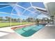 Relaxing screened pool overlooking the water and a patio dining area at 891 Harmony Ln, Englewood, FL 34223