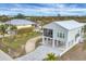 Inviting coastal home on stilts with a long driveway, lush landscaping, and convenient screened-in porch at 10451 Sherman St, Englewood, FL 34224