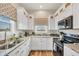 Bright kitchen with white cabinets, granite countertops, stainless steel appliances, and a charming window view at 10451 Sherman St, Englewood, FL 34224
