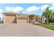 Lovely tan single story home with a tile roof, arched entry, and attached garage on a sunny day at 10544 Poughkeepsie Cir, Port Charlotte, FL 33981