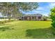 Well-manicured backyard with expansive lawn, privacy hedges, and screened-in lanai at 12650 Montigello Ct, Englewood, FL 34223