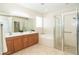 Bathroom featuring a double vanity, bathtub, and a glass-enclosed shower at 12650 Montigello Ct, Englewood, FL 34223