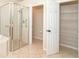 Bathroom featuring glass-enclosed shower, closet space, and tile flooring at 12650 Montigello Ct, Englewood, FL 34223