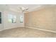 Bright primary bedroom featuring stylish accent wall, tile floors, and ample natural light from bay windows at 12650 Montigello Ct, Englewood, FL 34223