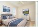 Bright bedroom with a tufted headboard, modern dresser, neutral walls, and complementary wall art at 12650 Montigello Ct, Englewood, FL 34223