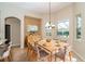 Bright dining room with wood table, modern chandelier, and large windows with beautiful outdoor views at 12650 Montigello Ct, Englewood, FL 34223