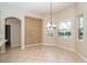 Light-filled dining area features tile floors, an elegant chandelier, and views of the outdoor landscape at 12650 Montigello Ct, Englewood, FL 34223