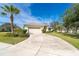 Exterior front view of a home with a two-car garage, a long driveway, and meticulously maintained landscaping at 12650 Montigello Ct, Englewood, FL 34223